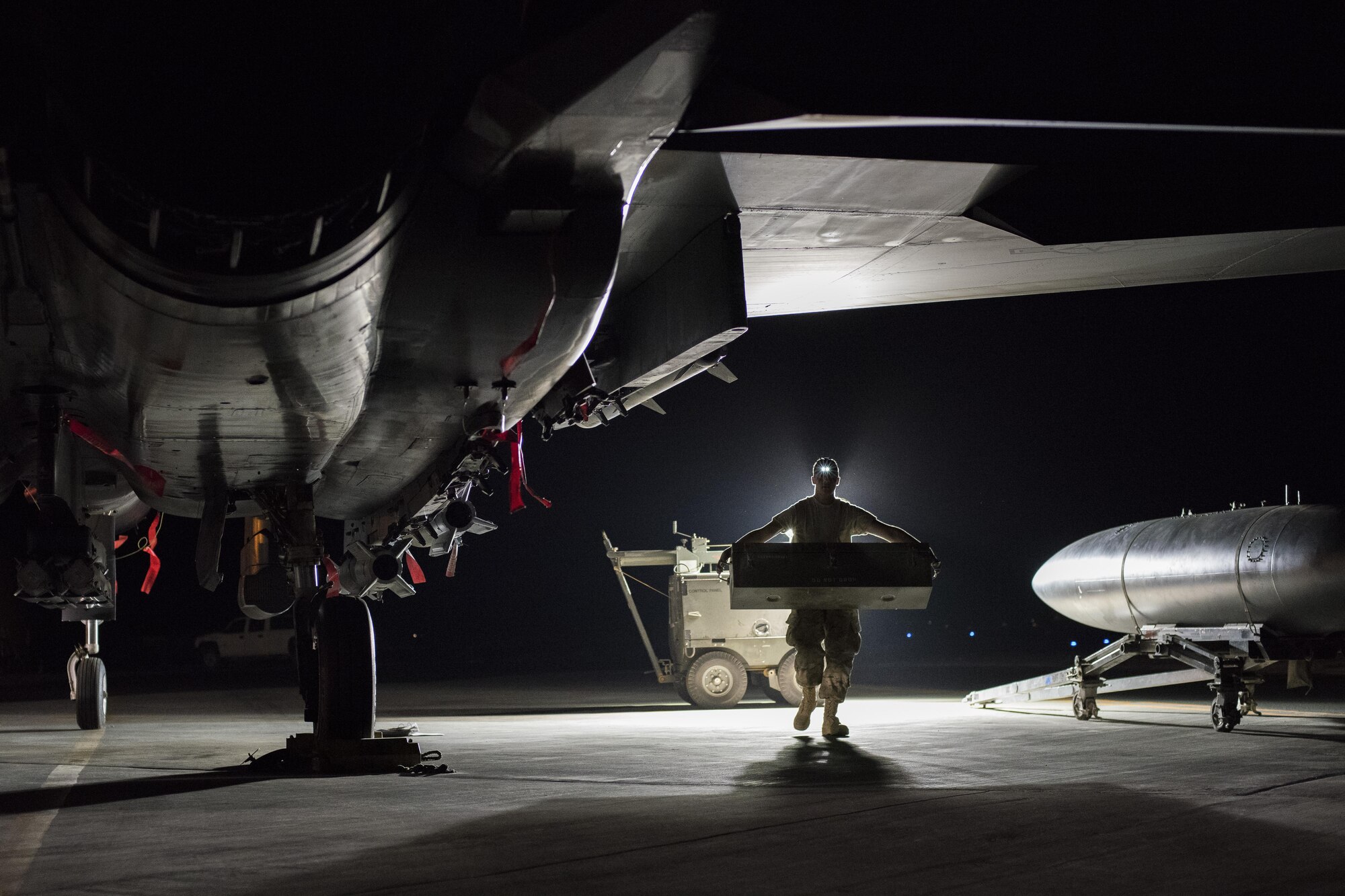 Airman 1st Class Harrison Goff, 332nd Expeditionary Maintenance Squadron weapons load crew member, carries an empty protective container for munitions August 12, 2017, in Southwest Asia. 332nd EMXS Airmen load F-15E Strike Eagles with a variety of bombs and missiles depending on the mission requirement. (U.S. Air Force photo/Senior Airman Damon Kasberg)