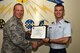 U.S. Air Force Lt. Col. Steven Watts, 17th Training Group Deputy commander, presents the 315th Training Squadron Officer Student of the Month award for August 2017 to 2nd Lt. Garrett Grove, 315th Training Squadron student, at Brandenburg Hall on Goodfellow Air Force Base, Texas, Sept. 8, 2017. (U.S. Air Force photo by Senior Airman Scott Jackson/Released)