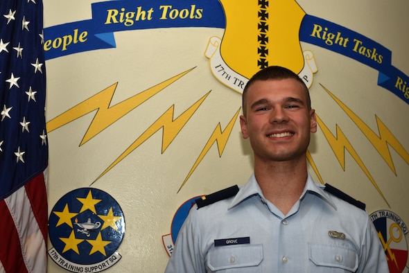 U.S. Air Force 2nd Lt. Garrett Grove, 315th Training Squadron student, stands before the 17th Training Group emblem at Brandenburg Hall on Goodfellow Air Force Base, Texas, Sept. 8, 2017. Grove is the Goodfellow Student of the Month spotlight for August 2017, a series highlighting Goodfellow students. (U.S. Air Force photo by Senior Airman Scott Jackson/Released)
