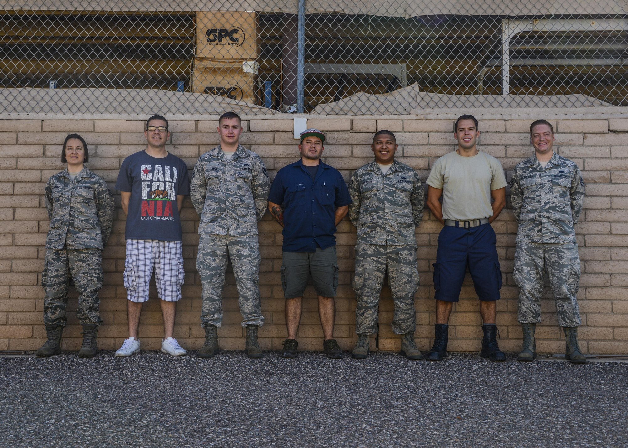 Daniel Villela, 56th Logistics Readiness Squadron mobile equipment mechanic, poses for a portrait with members of his team who helped identify and create a solution for a defect on mission essential equipment Sept. 12, 2017 at Luke Air Force Base, Ariz. Villela was the lead mechanic to provide the steps in reconfiguring and implementing a fix to the pintle hook mechanism for the bobtails that tow the F-35 on the flightline at Luke. (U.S. Air Force photo/Airman 1st Class Caleb Worpel).