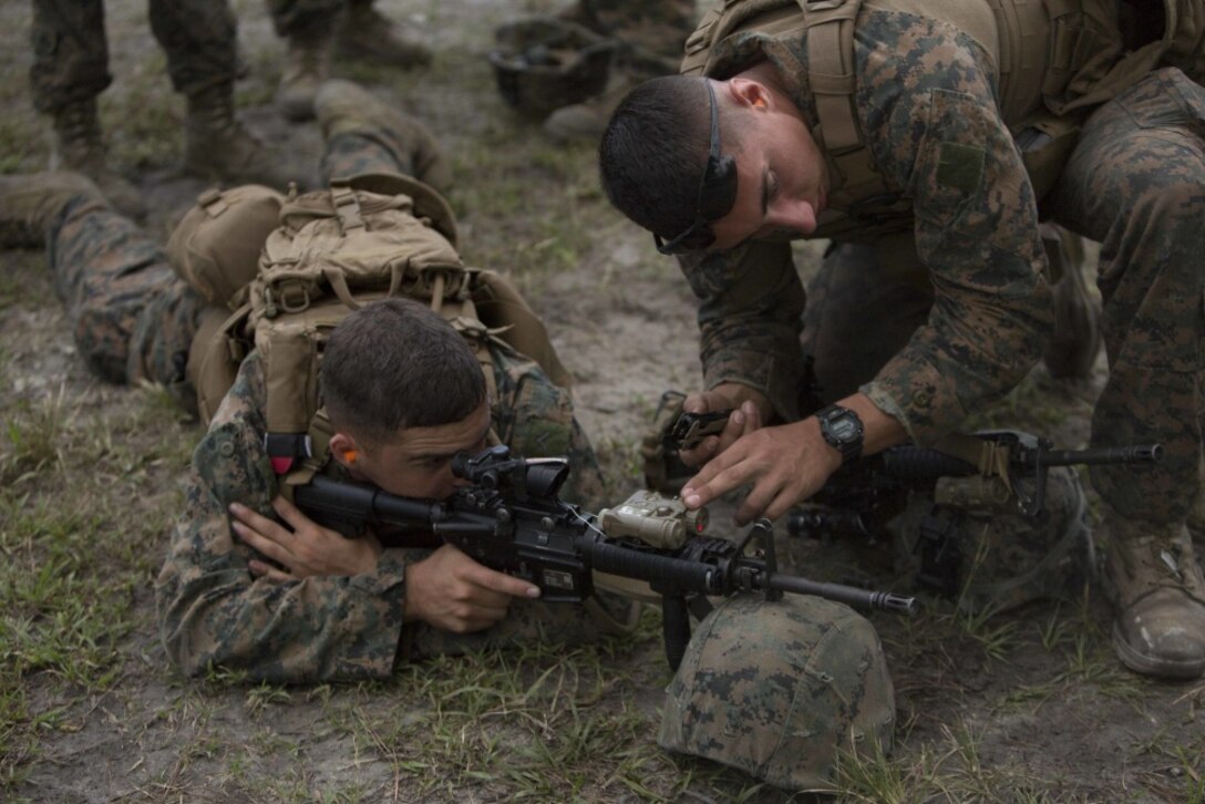 A Marine helps a shooter adjust his rifle’s infrared laser while waiting to fire during a combat marksmanship program for at Camp Lejeune, N.C., Aug 31, 2017. The Marines took part in the routine qualification training to maintain their combat skills for mission readiness. The Marines are with 2nd Light Armored Reconnaissance Battalion. (U.S. Marine Corps photo by Pfc. Nicholas Guevara)