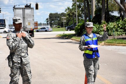 Specialist Brandon Moorley, military police for the 715th Military Police Company, and Airman 1st Class Kara Fredrickson, services apprentice at the125th Force Support Squadron, inspect vehicles at the Exit Control Point for the State Logistics Response Center Axillary Staging Area in Orlando, Fla. Sept. 13, 2017.