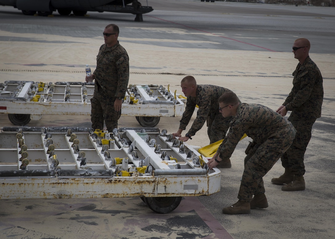 U.S. Marines with Joint Task Force - Leeward Islands, remove a pallet jack from underneath a container holding a Lightweight Water Purification System at Princess Juliana International Airport, Saint Martin, Sept. 13, 2017