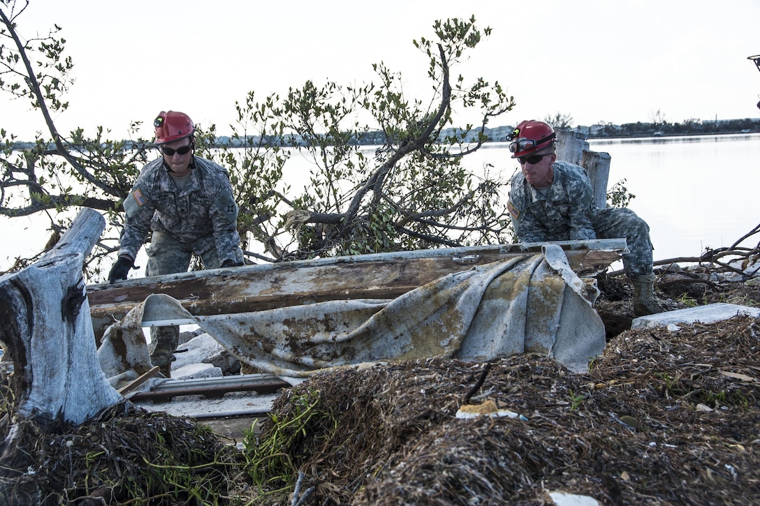 Soldiers search vessels shipwrecked by Hurricane Irma.