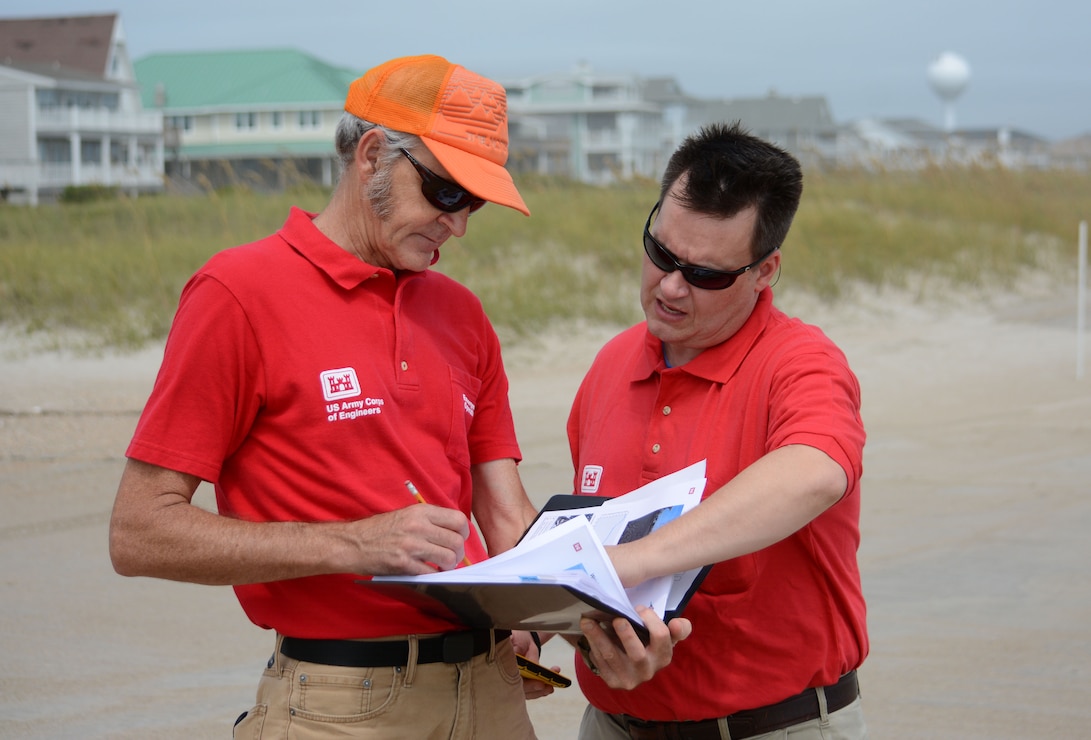 Coastal engineers Doug Wall, left, and Kevin Conner refer to a Preliminary Damage Assessment (PDA) notebook on Wrightsville Beach during their spot checks of specific sections of the beach. They uploaded data to the District's GIS server to be analyzed for any potential damage. (USACE photo by Hank Heusinkveld)