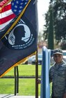 Airman 1st Class Jeremy Casem, 60th Aerial Port Squadron aerial porter, holds on to the U.S. flag to keep it from blowing over during a POW/MIA commemoration ceremony at Travis Air Force Base, Calif., on Sept. 15, 2017. POW/MIA recognition ceremonies are held to ensure that America remembers its responsibility to stand behind those who serve our nation and to account for those who do not return.