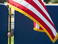 Airman 1st Class Jeremy Casem, 60th Aerial Port Squadron aerial porter, holds the U.S. flag during a POW/MIA commemoration ceremony to keep the flag from blowing over at Travis Air Force Base, Calif., on Sept. 15, 2017. There are currently 83,345 Americans that are missing from WWII, the Korean War, the Cold War, the Vietnam War, the 1991 Gulf War, Iraqi Freedom and Enduring Freedom.