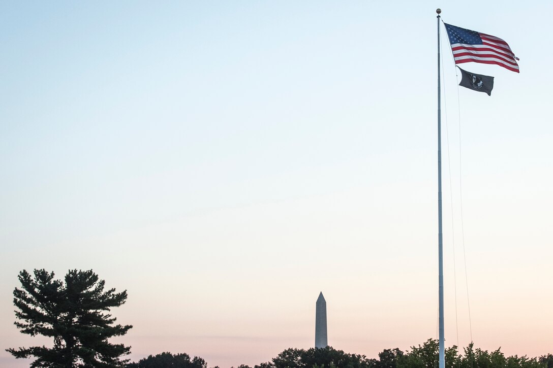 The U.S. and POW/MIA flags fly above the Pentagon.