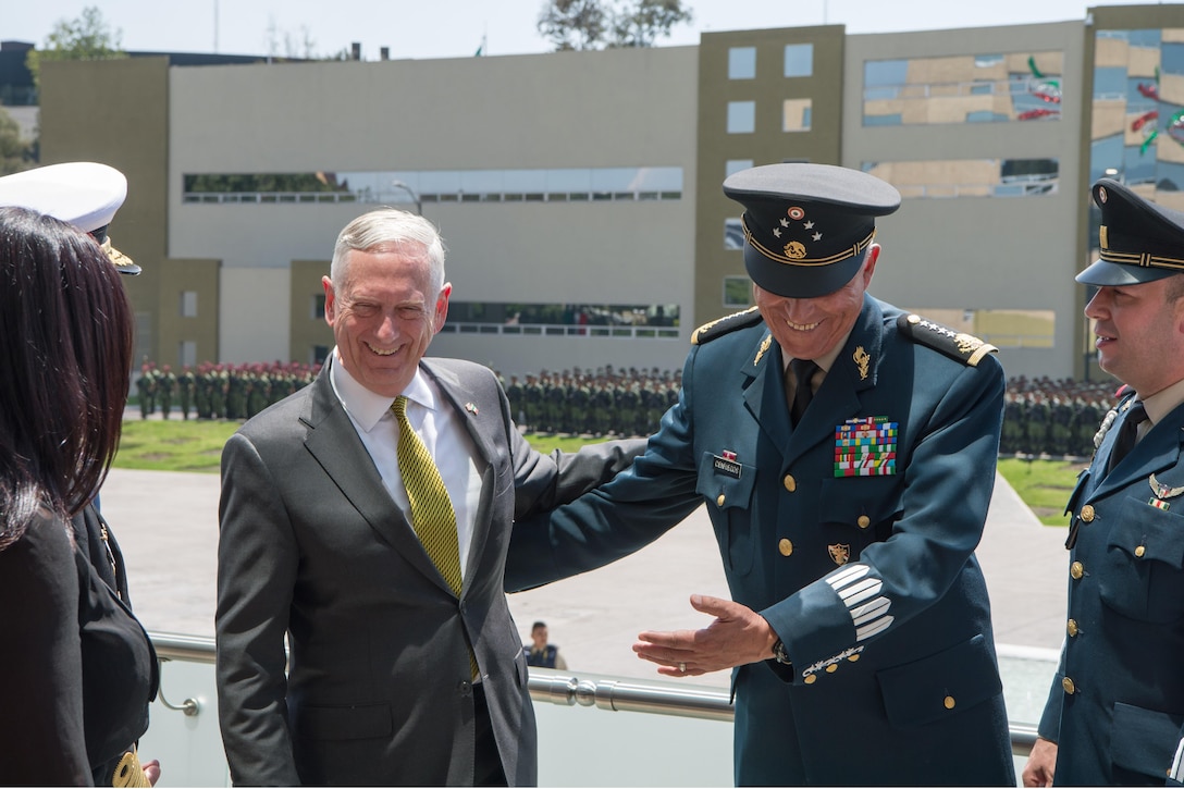 U.S. and Mexican defense leaders laugh together.