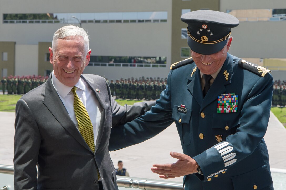 U.S. and Mexican defense leaders laugh together.