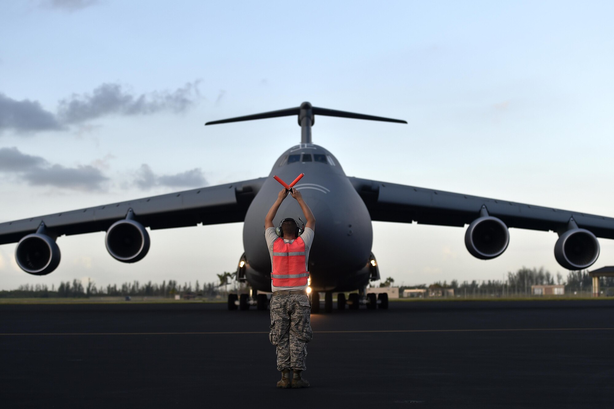 Staff Sgt. Ozzie Slawnikowski, 921st Contingency Response Squadron crew chief, marshals a C-5M Super Galaxy, Sep. 16, 2017, at Homestead Air Reserve Base, Fla. A 17-member contingency response team from the 821st Contingency Response Group from Travis Air Force Base, Calif., deployed to Homestead Air Reserve Base, Fla., to augment the 439th Airlift Wing airfield capabilities in support of Hurricane Irma relief efforts. (U.S. Air Force photo by Tech. Sgt. Liliana Moreno/Released)