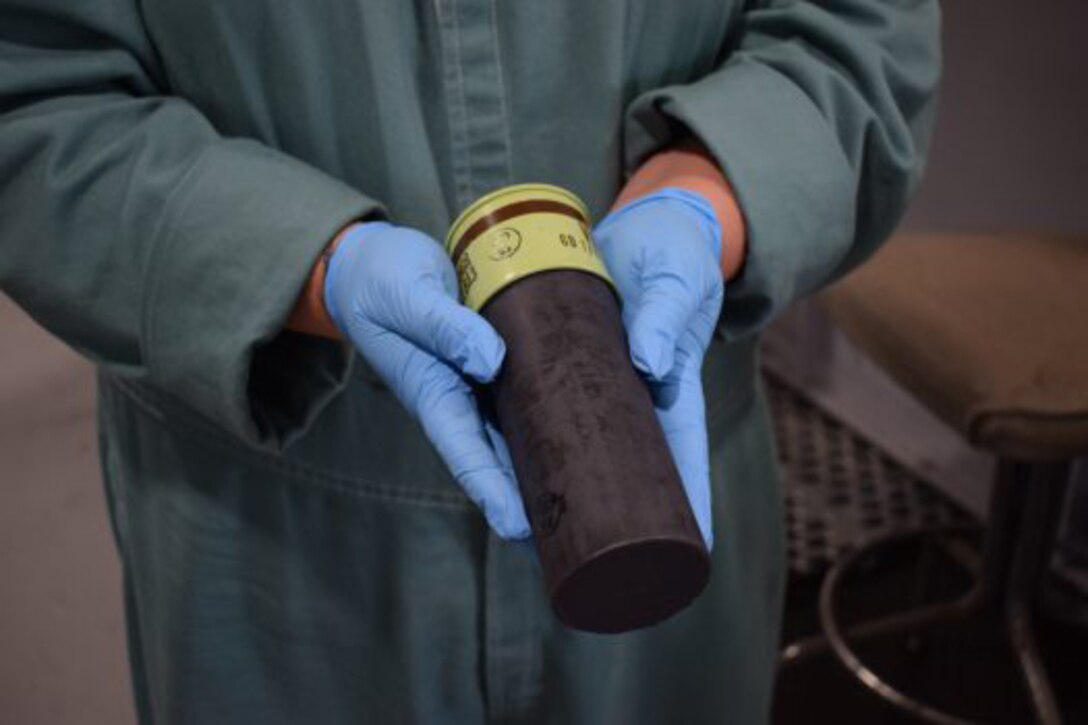 A scientist holds an obsolete grenade,