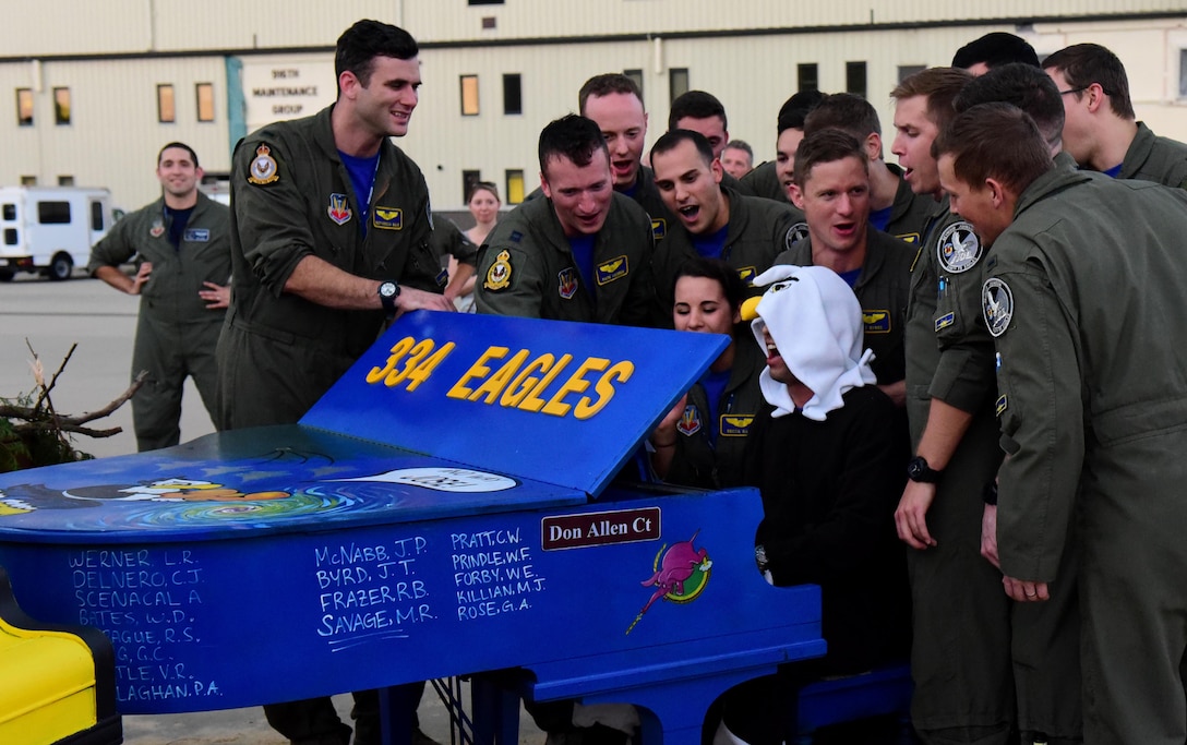 Members of the 334th Fighter Squadron sing together while a fellow Eagle plays their decorated piano during the 4th Fighter Wing Battle of Britain celebration, Sept. 15, 2017, at Seymour Johnson Air Force Base, North Carolina.
