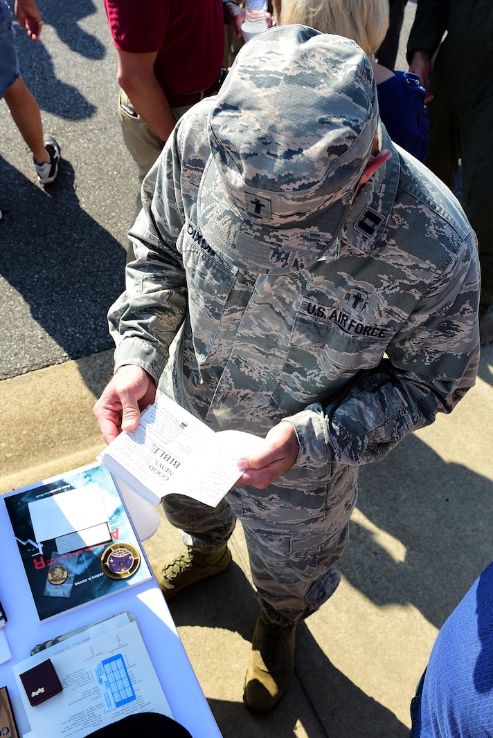 Capt. Douglas Dixon, 4th Fighter Wing chaplain, looks through a Bible taken out of the 1992 time capsule, Sept. 15, 2017, at Seymour Johnson Air Force Base, North Carolina. The capsule contained mementos from 1967, 1992, and will contain new items before being buried for another 25 years. (U.S. Air Force photo by Airman 1st Class Kenneth Boyton)