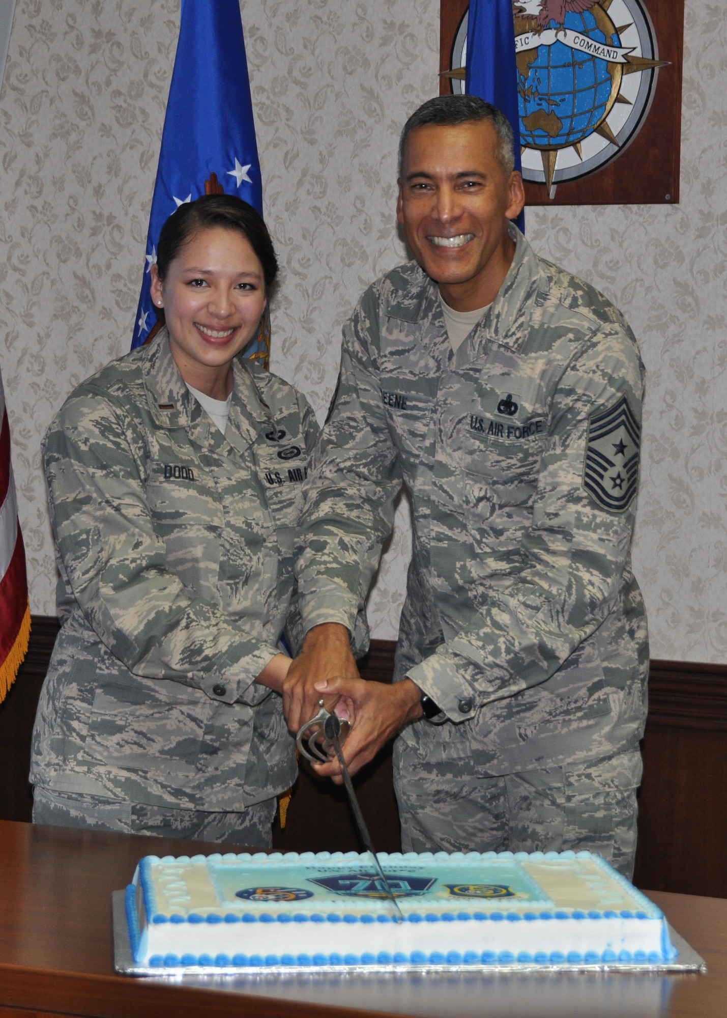 2nd Lt. Jayna Dodd, 5th Air Force Directorate of Intelligence, and Chief Master Sgt. Terrence Greene, 5 AF Command Chief Master Sergeant, prepare to cut the birthday cake celebrating the 70th anniversary of the U.S. Air Force, Sept. 18, 2017. Dodd and Greene represent the youngest and oldest members of 5 AF respectively. (U.S. Air Force photo by Maj. George Tobias)