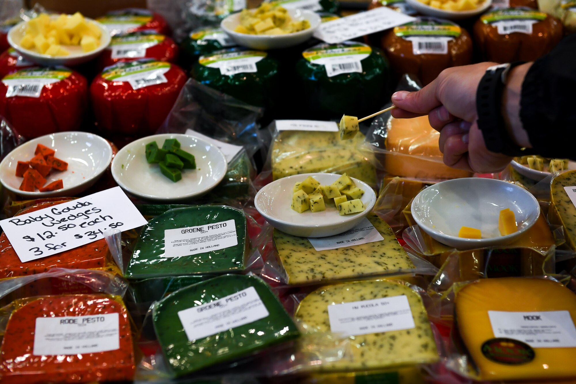 A 2017 Ramstein Bazaar patron grabs a cheese sample inside Hangar 1 on Ramstein Air Base, Germany, Sept 14, 2017.