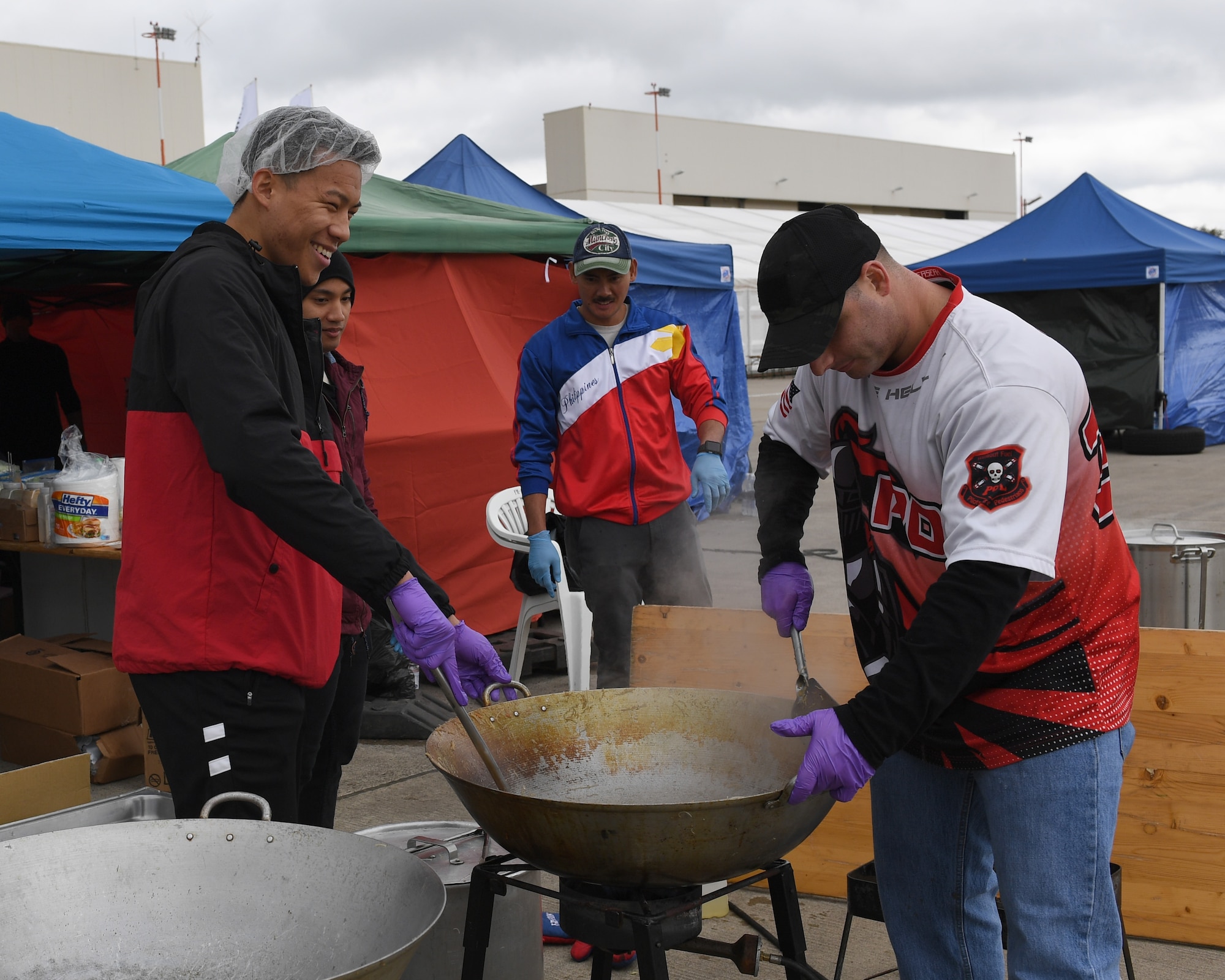 Volunteers at the 2017 Ramstein Bazaar cook Filipino noodles on the Ramstein Air Base flightline, Germany, Sept 15, 2017