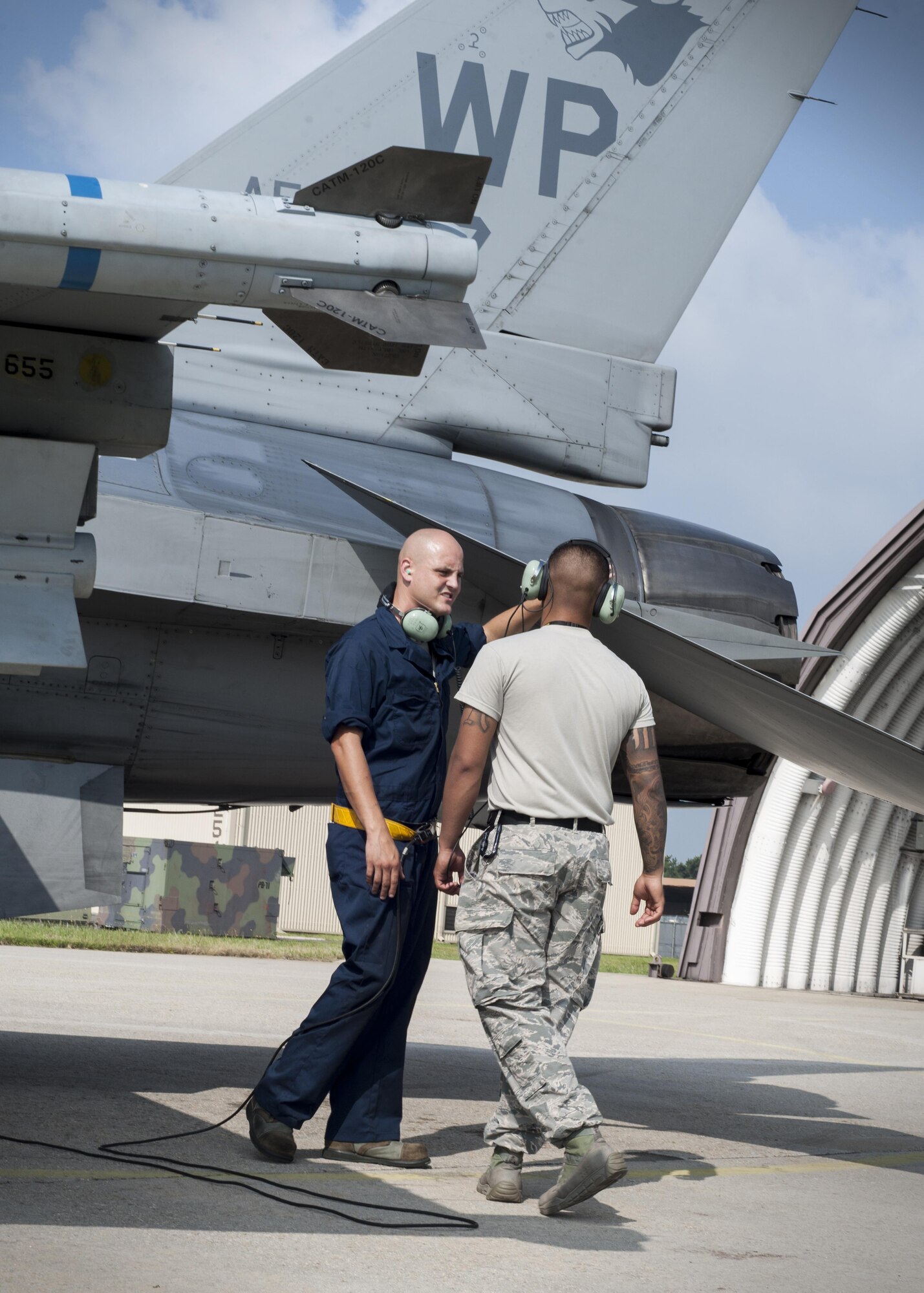U.S. Air Force Staff Sgt. Eugene Travis, 8th Air Maintenance Squadron crew chief, briefs Airman 1st Class Anthony Martinez, 8th Security Forces Squadron defender, while participating in the “Job Swap” event at Kunsan Air Base, Republic of Korea, Sept. 12, 2017. The week-long event was to give 8th SFS defenders a better look at the assets that they are protecting day in and day out. (U.S. Air Force photo by Staff Sgt. Victoria H. Taylor)