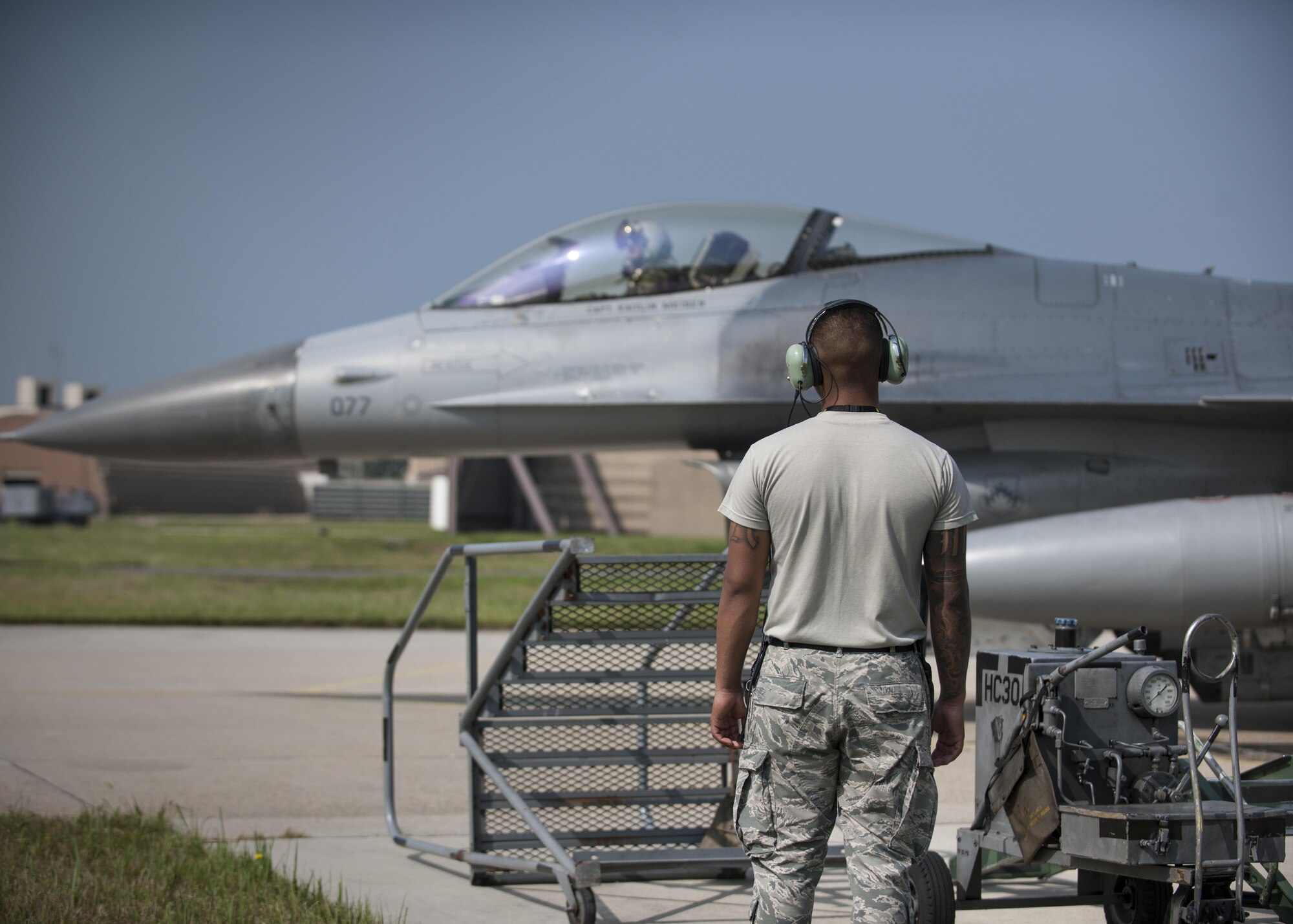 Airman 1st Class Anthony Martinez, 8th Security Forces Squadron defender, watches as an F-16 Fighting Falcon prepares to taxi during the “Job Swap” event at Kunsan Air Base, Republic of Korea, Sept. 12, 2017.  The event aimed to give a hands-on look at the mission that 8th SFS defenders are supporting and protecting. (U.S. Air Force photo by Staff Sgt. Victoria H. Taylor)