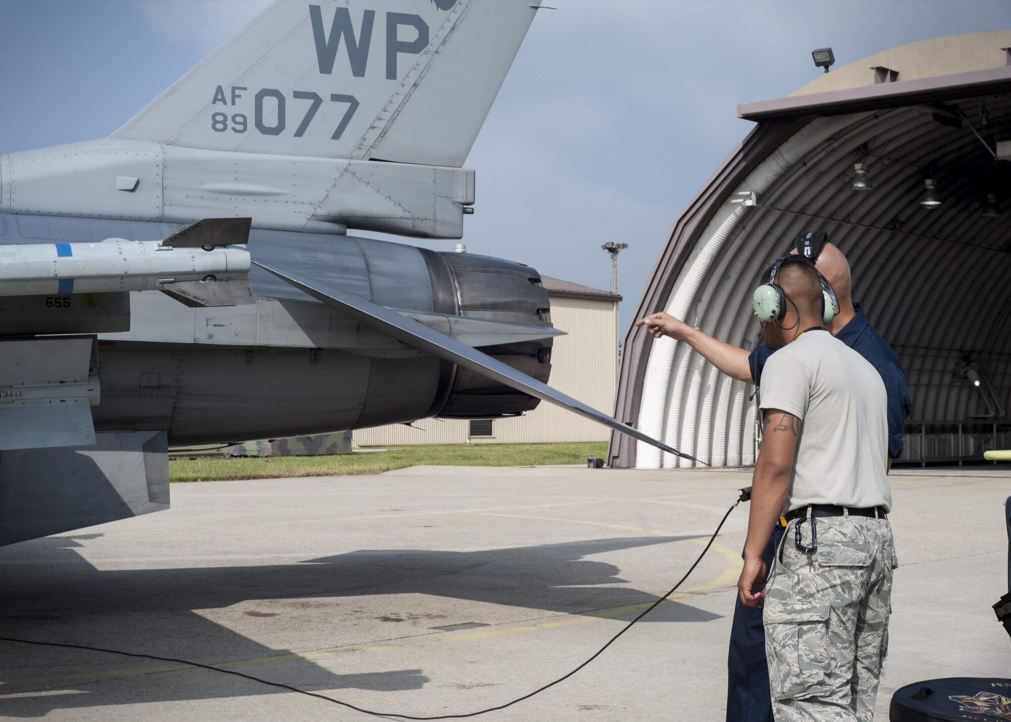 U.S. Air Force Staff Sgt. Eugene Travis, 8th Air Maintenance Squadron crew chief, briefs Airman 1st Class Anthony Martinez, 8th Security Forces Squadron defender, while participating in the “Job Swap” event at Kunsan Air Base, Republic of Korea, Sept. 12, 2017. The event aimed to give a hands-on look at the mission that 8th SFS defenders are supporting and protecting. (U.S. Air Force photo by Staff Sgt. Victoria H. Taylor)