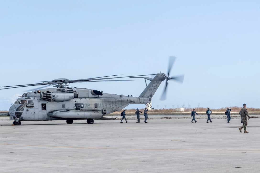 Sailors and Marines disembark a CH-53 Sea Stallion helicopter to aid in the aftermath of Hurricane Irma.