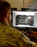 An intelligence officer for the 118th Intelligence, Surveillance, and Reconnaissance Group based at Joint Base Berry Field in Nashville, Tenn., assesses areas in Puerto Rico without power. The box in the top right of his screen is a before image provided by NASA, and the main image is the current power situation on September 15.