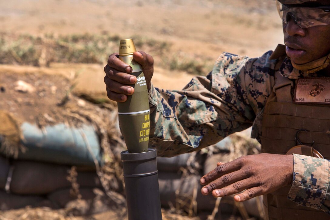 Marine loads a 60 mm mortar during an advanced infantry course.