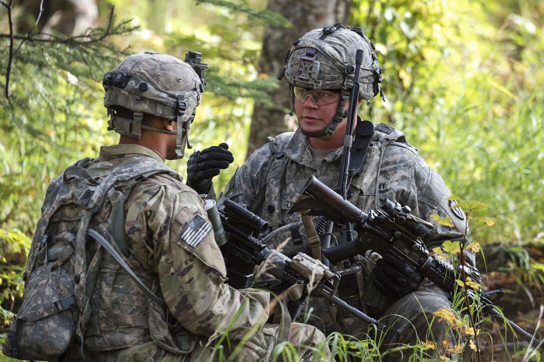 Army Sgt. James Luce, right, relays directions to a team member during live-fire training.