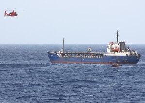A Coast Guard Helicopter Interdiction Tactical Squadron MH-65 Dolphin helicopter crew and a small boat crew from the Coast Guard Cutter Tahoma arrive to a 226-foot tanker in the Caribbean in August, 2017