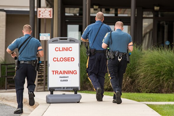 Three Delaware State Police troopers approach the entrance of the Base Clinic during an active shooter exercise Sept. 12, 2017, at Dover Air Force Base, Del. More than 30 DSP personnel assisted the 436th Security Forces Squadron to help neutralize the active shooters during this joint training exercise. (U.S. Air Force photo by Roland Balik)
