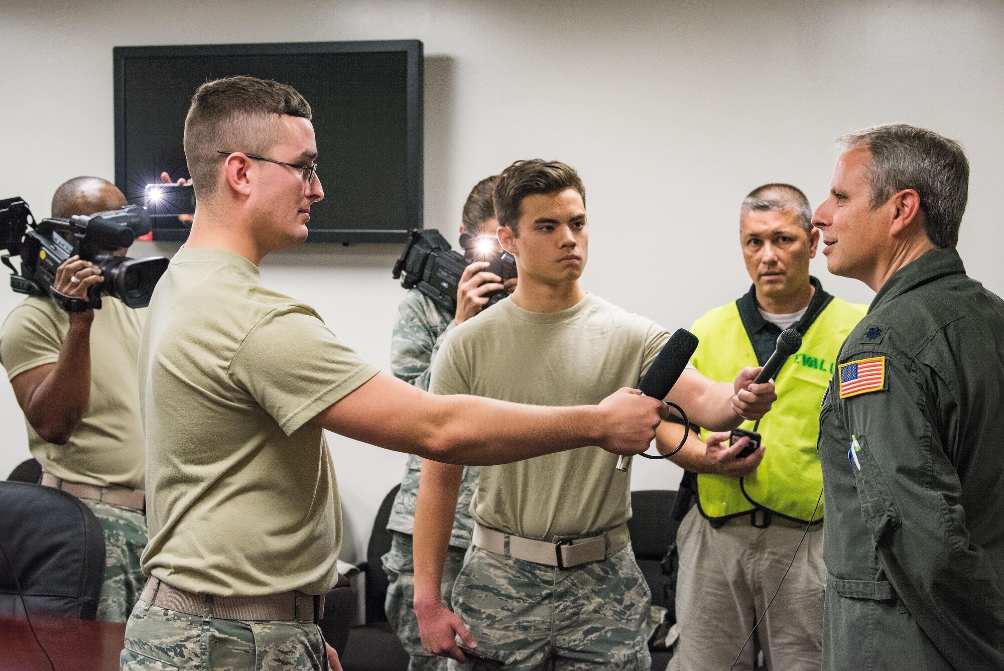 Lt. Col. Timothy Williams, 436th Airlift Wing director of staff, right, answers questions from Team Dover personnel posing as members of the press during an active shooter exercise Sept. 12, 2017, at Dover Air Force Base, Del. Left to right, Senior Airman Moss Purcell, 436th Aerospace Medicine Squadron public health technician; Airman 1st Class Robert Izumikawa, 436th Medical Support Squadron medical laboratory technician; and Sgt. Richard Bratz, Delaware State Police public information officer, played the roles of persistent press members who asked Williams about the active shooter situation at the Base Clinic. The simulated press conference was used as a training opportunity for wing leadership to communicate to the media regarding potential real-world occurrences in the future. (U.S. Air Force photo by Roland Balik)