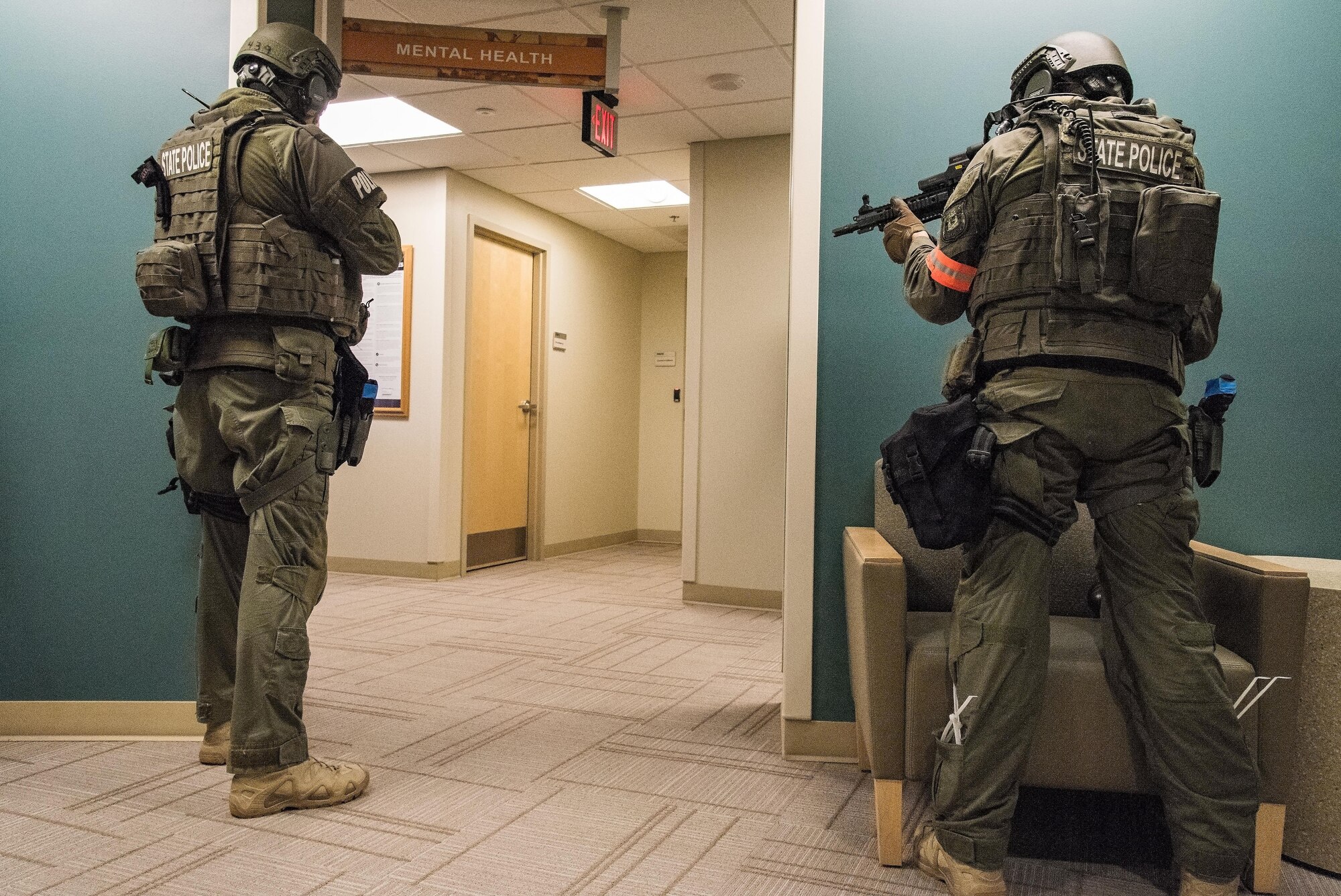 Two Delaware State Police Special Weapons and Tactics team members take positions outside of the Mental Health clinic during an active shooter exercise Sept. 12, 2017, at the Base Clinic, Dover Air Force Base, Del. DSP SWAT team members breached a door to neutralize the second exercise active shooter and rescue numerous hostages. (U.S. Air Force photo by Roland Balik)