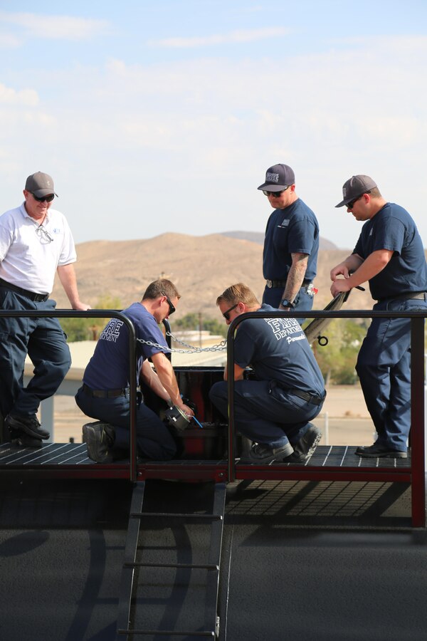Craig Skidmore, instructor with Advanced Entertainment Technologies, a special effects company out of Monrovia, Calif. trains firefighters Kevin Vanderboom, Bradley Watson, David Pacileo and Kevin Watson on some of the functions of the new three-domed railcar simulator aboard Marine Corps Logistics Base Barstow, Calif. Aug. 30. The simulator, designed and created by AET, offers a wide range of realistic railcar simulation options in one large device so that emergency responders can have hands-on training with railway emergencies.