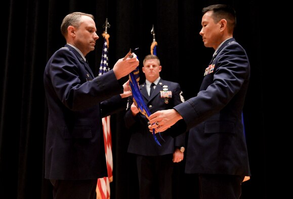 Col. Donald Wilson, Air and Cyberspace Intelligence Group commander, and Lt. Col. Burt Okamoto, Integrated Command Control Communication Computers Intelligence Surveillance Reconnaissance Analysis Squadron commander, reveal the new ACX guidon during a re-designation ceremony Sept. 8, at the National Air and Space Intelligence Center.