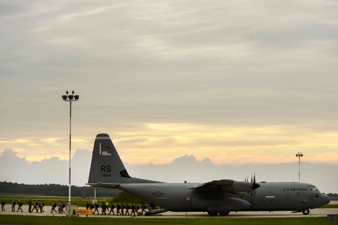 Airmen offload from a C-130 Hercules aircraft.