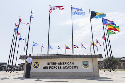 Lt. Col. Isaac Davidson, Inter-American Air Forces Academy new commandant, proudly stands in front of the circle of international flags Sept. 15 at the academy's headquarters at Joint Base San Antonio-Lackland, Texas. Davidson says he will continue to strengthen international relationships through education and training. IAAFA is preparing to celebrate 75 years of existence in March 2018 with its western hemisphere partners.