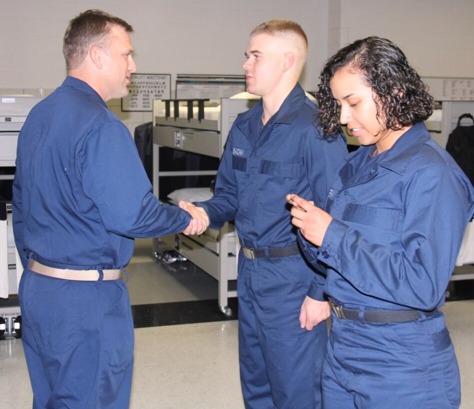 IMAGE: 170907-N-TS560-110 
GREAT LAKES, Ill. (Sept. 8, 2017) - Combat Direction Systems Activity Dam Neck Commanding Officer Cmdr. Andrew J. Hoffman (left) presents his command coin to Seaman Recruit Kurtis Bacha of Ringgold, Ga., after presenting one to Seaman Recruit Jessica Barrera of Riverside, Calif.  Hoffman was among five CDSA personnel who traveled to Recruit Training Command Great Lakes after sponsoring Division 287 during their initial Navy training.