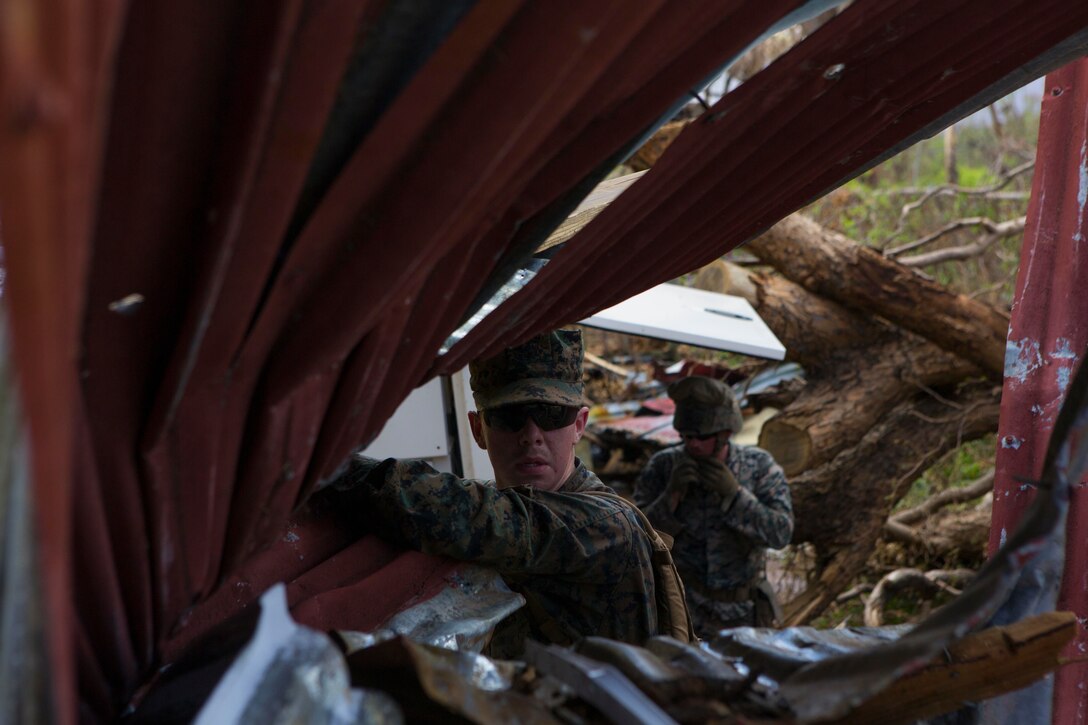 U.S. Marine Corps Sgt. Austin C. Morgan, an assaultman with Battalion Landing Team 2nd Battalion, 6th Marine Regiment, 26th Marine Expeditionary Unit (MEU), to clear debris at a local fire station that was affected by Hurricane Irma in St. John, U.S. Virgin Islands, Sept. 17, 2017.