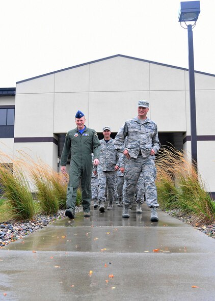 Brig. Gen. Christopher Ireland, deputy commander of Canadian North American Aerospace Defense Region, and Deputy Combined/Joint Force Air Component Commander for 1 Canadian Air Division, Winnipeg, Manitoba, Canada, right, talks with Lt. Col. Kendall Gillespie, commander of the 348th Reconnaissance Squadron, left, followed by Chief Master Sgt. Brian Thomas, commander of the 319th Air Base Wing, center, before heading to the final stop of his base tour Sept. 15, 2017, on Grand Forks AFB, N.D. Ireland received a mission brief, and visited the 319th Communications Squadron, 69th Maintenance Squadron, 319th Operations Support Squadron and 348th RS. (U.S. Air Force photo by Airman 1st Class Elora J. Martinez)