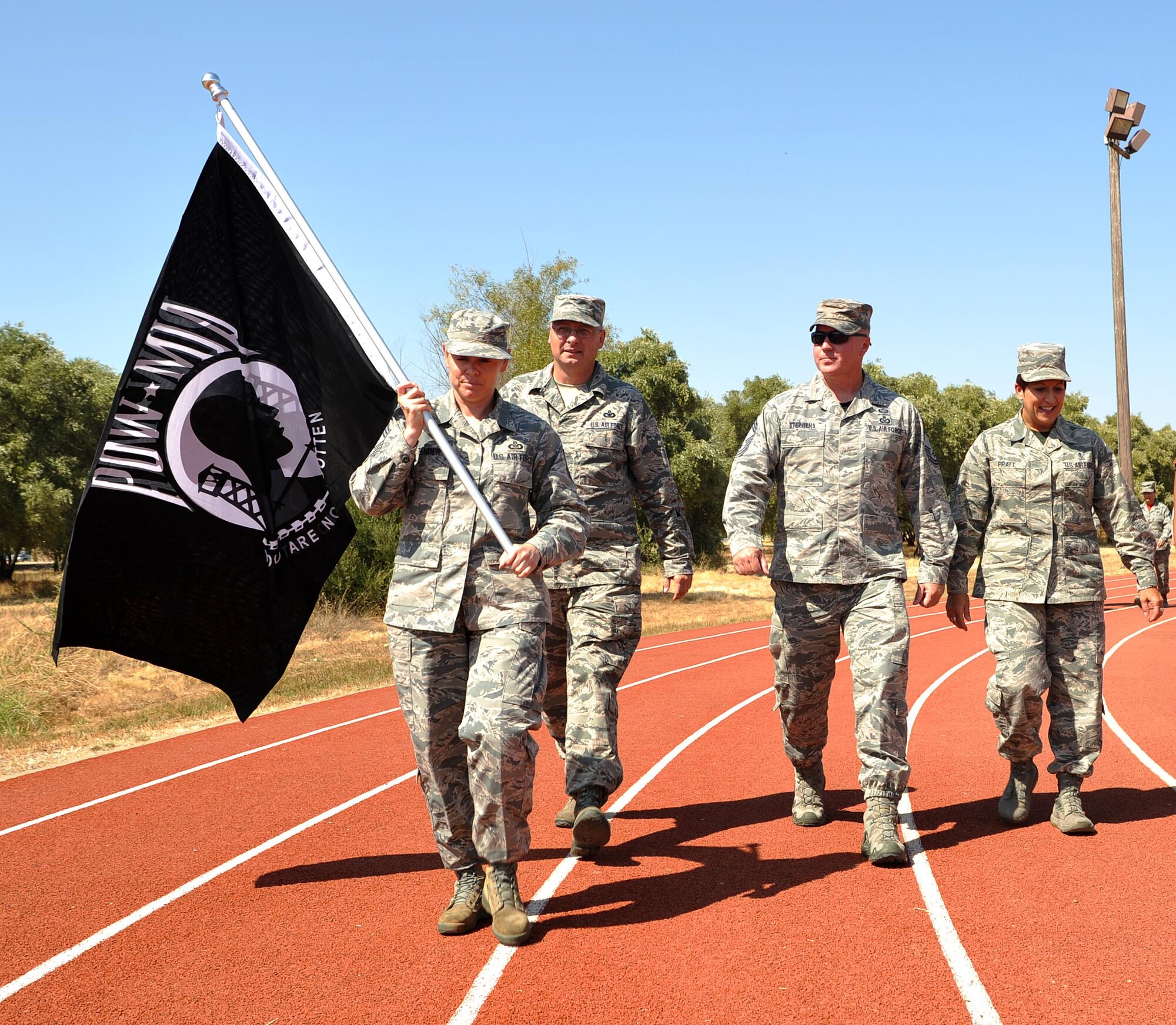 Chief Master Sgt. Jessica Bender, 9th Reconnaissance Wing command chief, carries a POW/MIA flag during a 24 hour nonstop run honoring POW/MIA Recognition Day