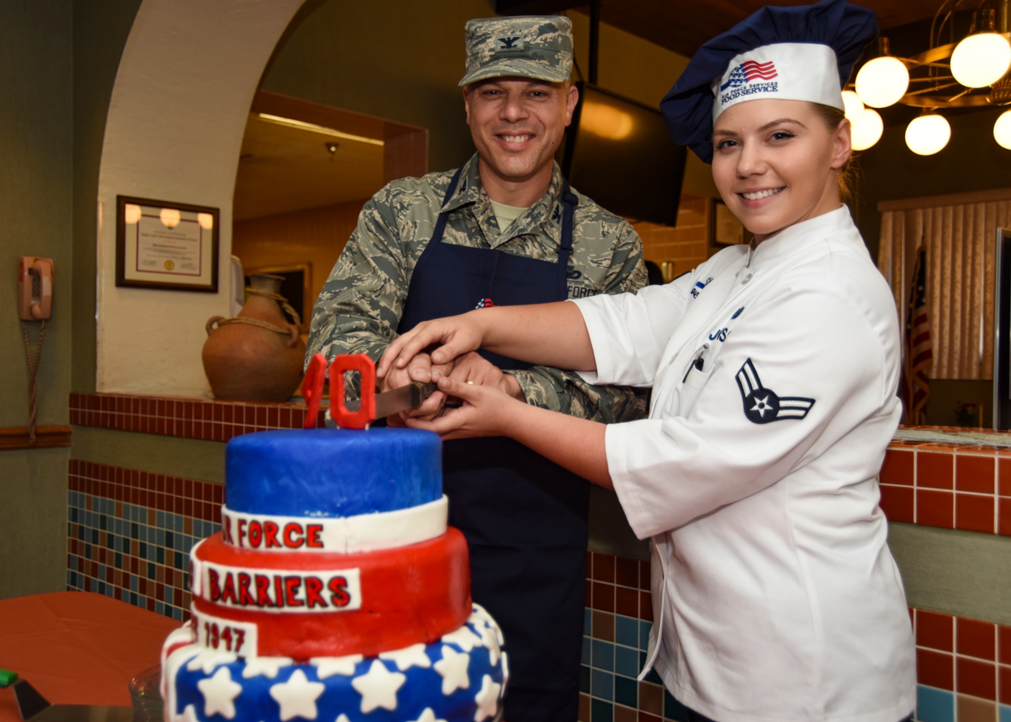 Col. Mathew Boschert, 99th Mission Support Group commander, and Airman 1st Class Rebecca Johnson, 99th Force Support Squadron chef, prepare to cut the Air Force's 70th anniversary cake at Nellis Air Force Base, Nevada, Sept. 18, 2017. The cake took more than three days to prepare, perfect and present before being served to Airmen at the Crosswinds Inn dining facility. (U.S. Air Force photo by Airman 1st Class Andrew D. Sarver/Released)