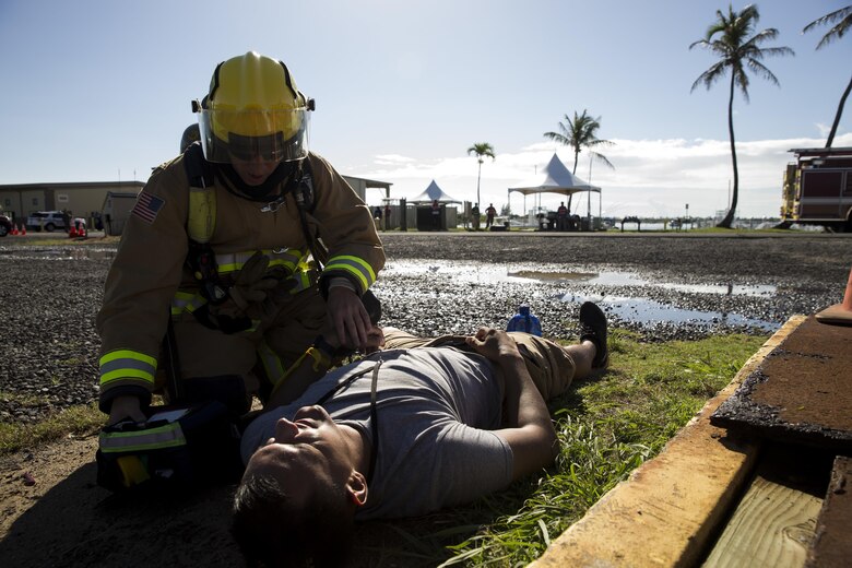 A fire fighter with the Marine Corps Base Hawaii (MCBH) Fire Department aids a simulated victim during the Anti-Terrorism/Force Protection Exercise Lethal Breeze, aboard MCBH, Sept. 12, 2017. The exercise combined multiple agencies, on and off the installation, to respond to a simulated attack, mass casualty scenario, and an environmental oil spill. Exercise Lethal Breeze provided hands-on experience and training to prepare MCBH to protect personnel, facilities, and other assets from all threats and hazards. (U.S. Marine Corps Photo by Sgt. Alex Kouns)