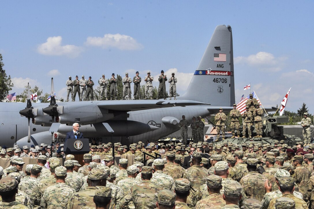 The U.S. vice president gives an address as some troops stand on an airplane's wing.