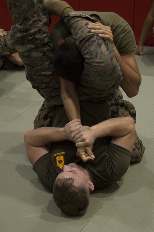 Cpl. Jody Scott teaches a Marine how to do an armbar during a grueling Marine Corps Martial Arts Program class