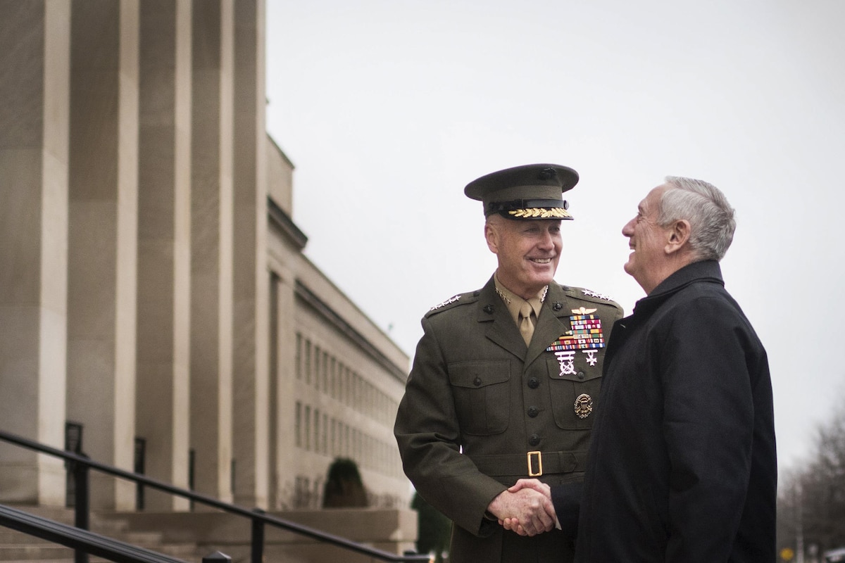 Defense Secretary James N. Mattis smiles as he shakes hands with Marine Corps Gen. Joe Dunford outside the Pentagon.