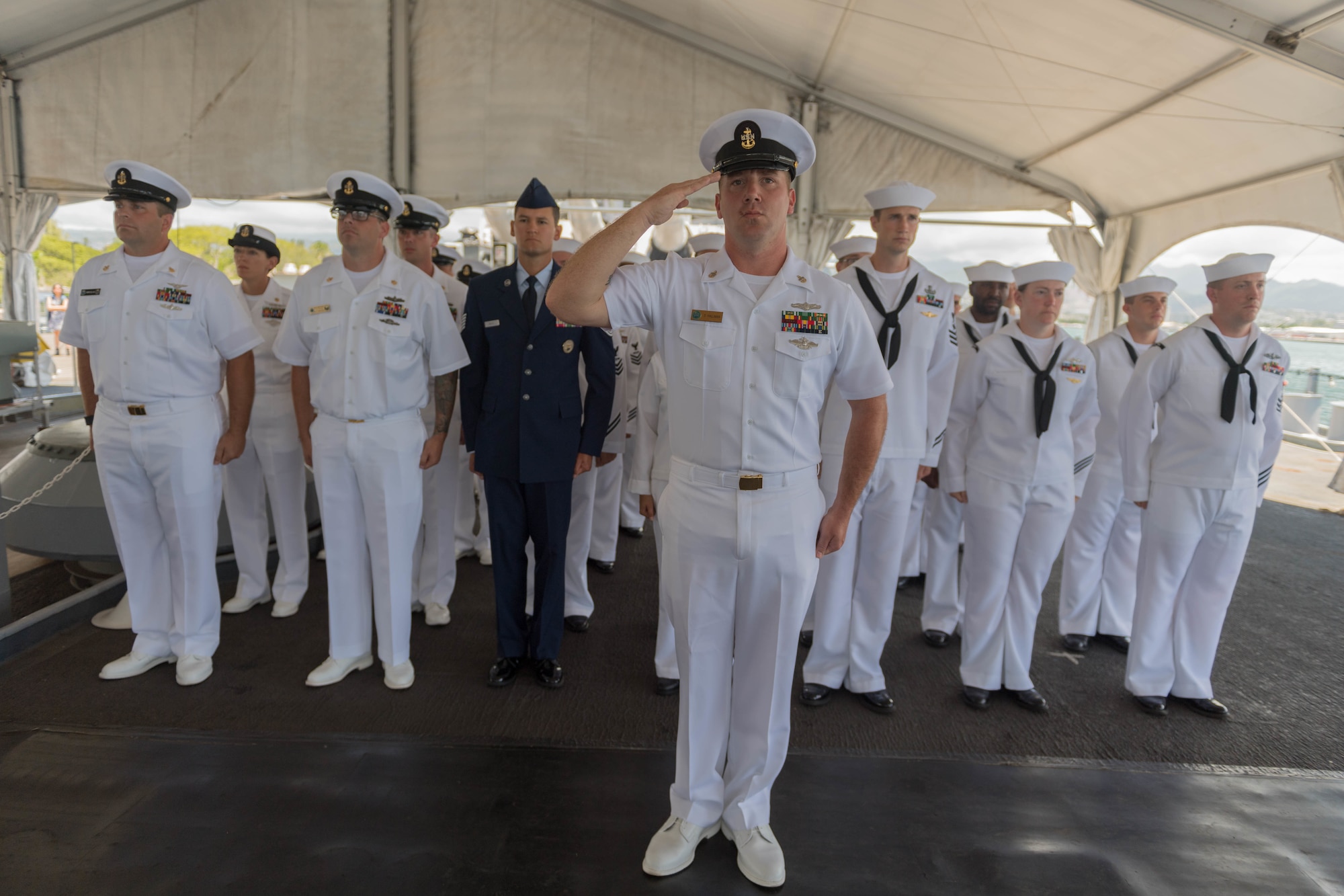 Sailors and one Airman salute in formation.