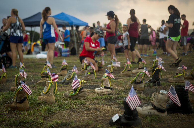 A display of boots with information of fallen service members are set in a formation during the Fisher House Hero and Remembrance Run, Walk or Roll 8k on Ford Island aboard Joint Base Pearl Harbor-Hickam, Sept. 9, 2017. The road was adorned with over 7,500 military boots decorated with American flags, name tags with a photo of the service member, and information on the combat tour they were serving or where they were stationed. The free event was open to the public and military to honor those we have lost in the service since Sept. 11, 2001. (U.S. Marine Corps photo by Sgt. Zachary Orr)