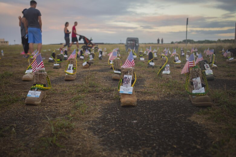 A display of boots with information of fallen Service members are set in a formation during the Fisher House Hero and Remembrance Run, Walk or Roll 8k on Ford Island aboard Joint Base Pearl Harbor-Hickam, Sept. 9, 2017. The road was adorned with over 7,500 military boots decorated with American flags, name tags with a photo of the service member, and information on the combat tour they were serving or where they were stationed. The free event was open to the public and military to honor those we have lost in the service since Sept. 11, 2001. (U.S. Marine Corps photo by Sgt. Zachary Orr)