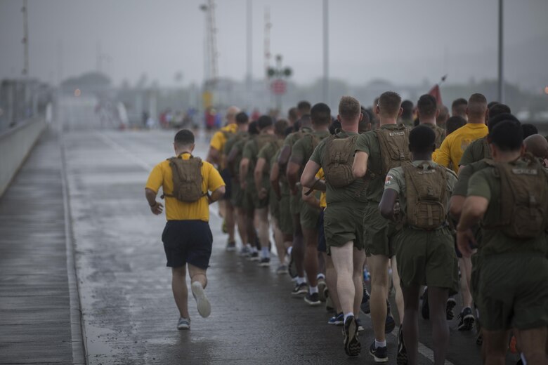 A U.S. Sailor with 2nd Battalion, 3rd Marine Regiment calls cadence during the Fisher House Hero and Remembrance Run, Walk or Roll 8k on Ford Island aboard Joint Base Pearl Harbor-Hickam, Sept. 9, 2017. The road was adorned with over 7,500 military boots decorated with American flags, name tags with a photo of the service member, and information on the combat tour they were serving or where they were stationed. The free event was open to the public and military to honor those we have lost in the service since Sept. 11, 2001. (U.S. Marine Corps photo by Sgt. Zachary Orr)