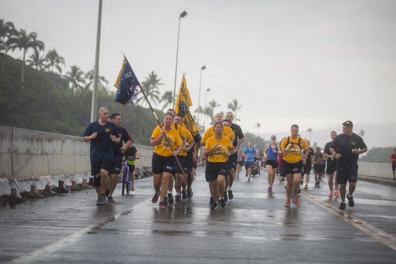 U.S. Sailors run in formation during the Fisher House Hero and Remembrance Run, Walk or Roll 8k on Ford Island aboard Joint Base Pearl Harbor-Hickam, Sept. 9, 2017. The road was adorned with over 7,500 military boots decorated with American flags, name tags with a photo of the service member, and information on the combat tour they were serving or where they were stationed. The free event was open to the public and military to honor those we have lost in the service since Sept. 11, 2001. (U.S. Marine Corps photo by Sgt. Zachary Orr)